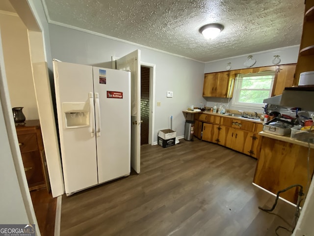 kitchen featuring white refrigerator with ice dispenser, a textured ceiling, dark wood finished floors, brown cabinets, and light countertops