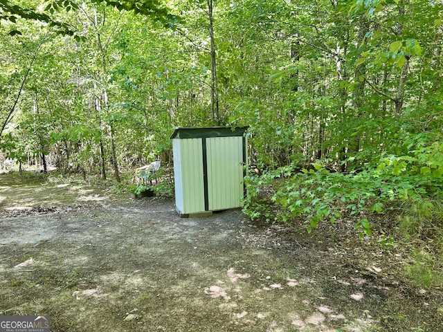 view of shed with a view of trees