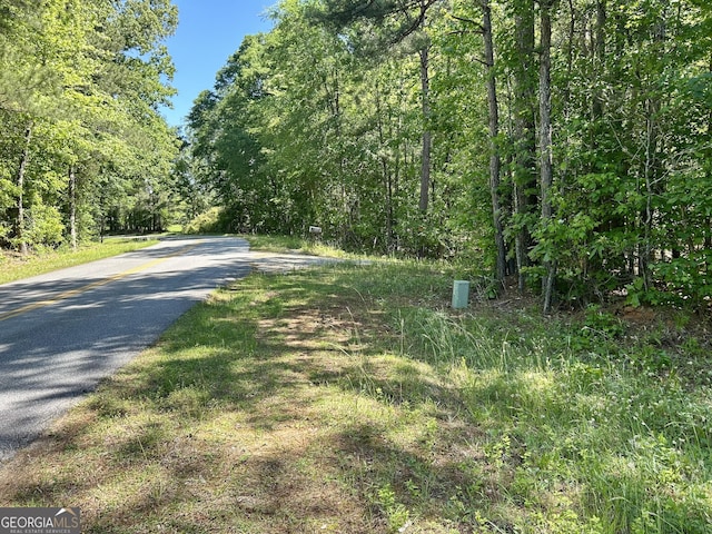view of road with a wooded view