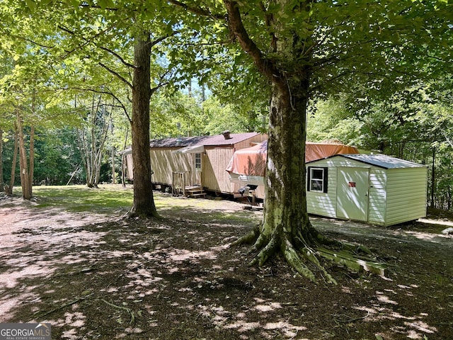 view of yard featuring a storage shed and an outdoor structure