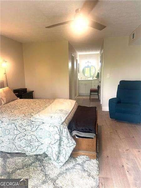 506 Park Ridge Cir, Marietta, GA 30068 - bedroom featuring wood finished floors, ensuite bath, ceiling fan, and a textured ceiling
