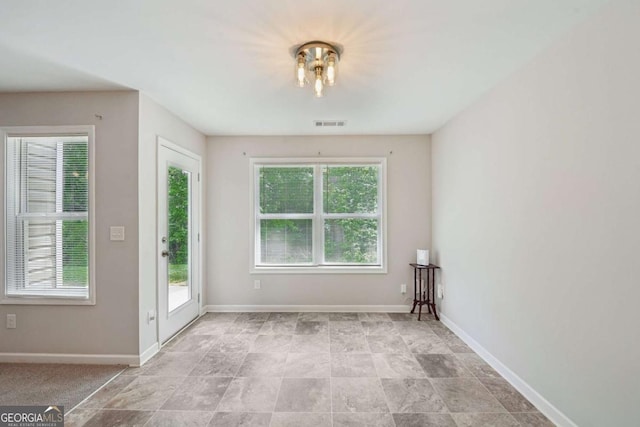 spare room featuring visible vents and baseboards