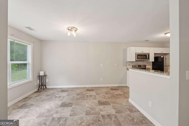 interior space featuring baseboards and visible vents