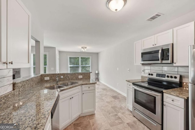 kitchen featuring a sink, white cabinetry, decorative backsplash, and appliances with stainless steel finishes