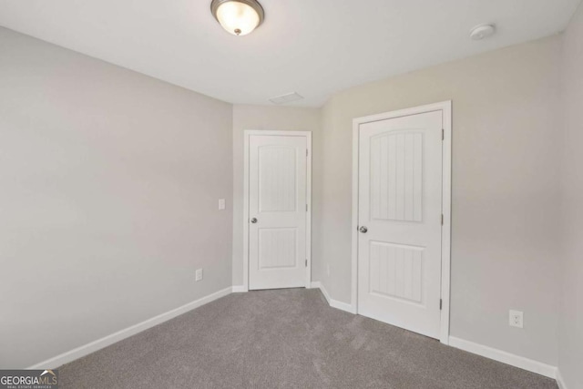 unfurnished bedroom featuring carpet flooring and baseboards