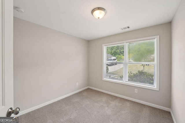 spare room with carpet, visible vents, and baseboards