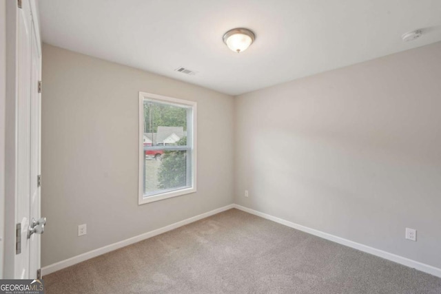 empty room featuring carpet flooring, visible vents, and baseboards