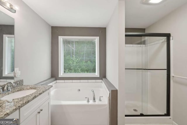 bathroom featuring a stall shower, vanity, and a bath