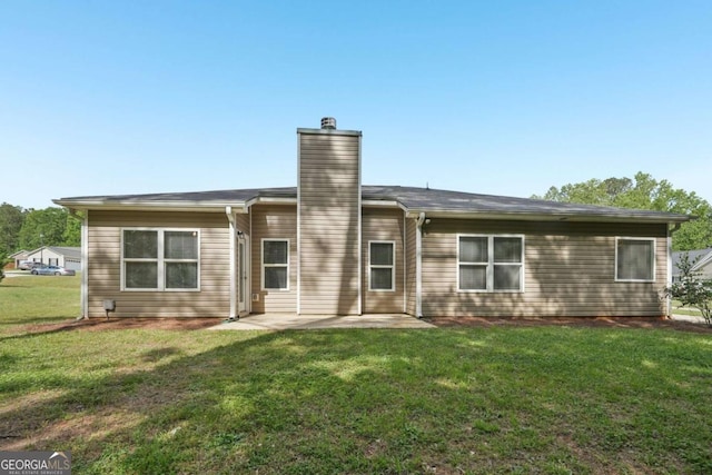 rear view of property featuring a patio area, a chimney, and a lawn