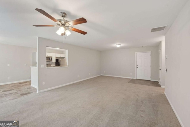 unfurnished living room with visible vents, baseboards, a ceiling fan, and light carpet