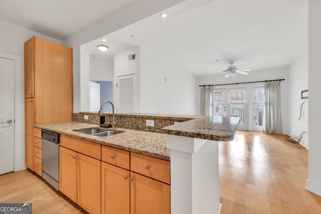 kitchen featuring light stone countertops, dishwasher, ceiling fan, a sink, and a peninsula