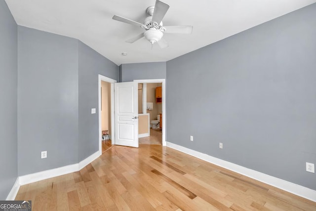 unfurnished bedroom with a ceiling fan, light wood-style flooring, and baseboards