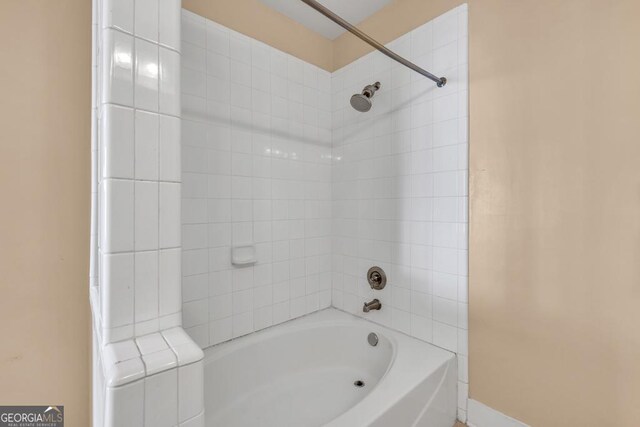 bathroom featuring baseboards and bathtub / shower combination