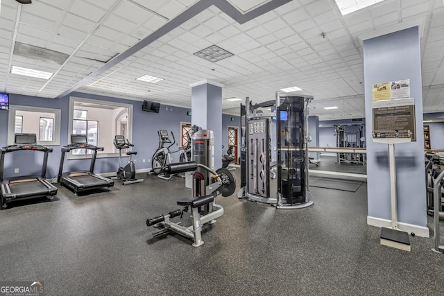 workout area featuring a drop ceiling and baseboards