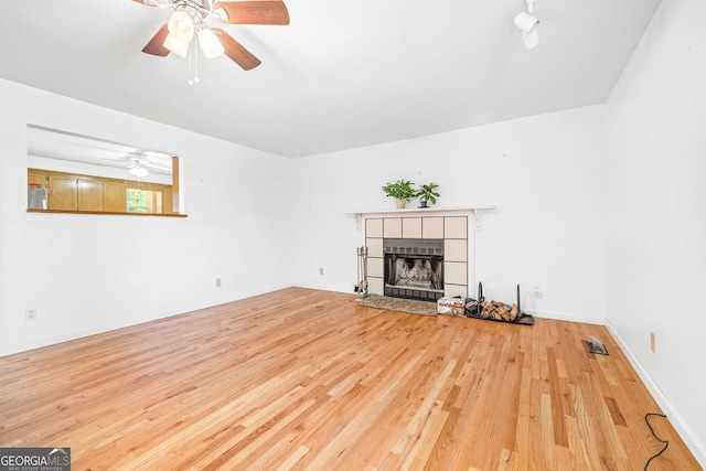 303 Jennys Cove Rd, Cleveland, GA 30528 - unfurnished living room with wood-type flooring, a ceiling fan, visible vents, and a tile fireplace