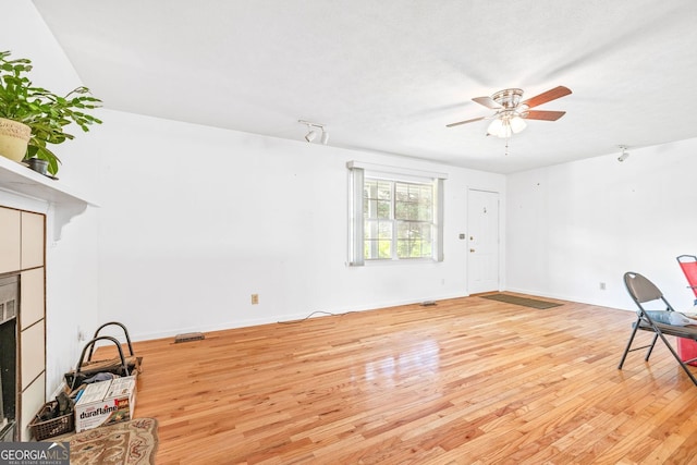 303 Jennys Cove Rd, Cleveland, GA 30528 - unfurnished living room with light wood finished floors, a ceiling fan, a fireplace, and baseboards