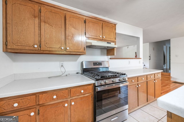 303 Jennys Cove Rd, Cleveland, GA 30528 - kitchen featuring stainless steel range with gas stovetop, brown cabinets, light countertops, and under cabinet range hood