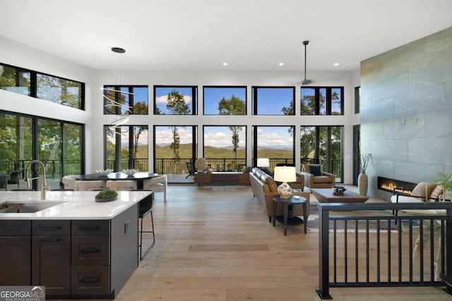 714 Scouts Overlook, Morganton, GA 30560 - living area with light wood-type flooring, a tiled fireplace, a towering ceiling, and recessed lighting