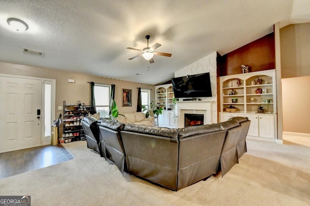 living room with lofted ceiling, ceiling fan, a fireplace, and light colored carpet