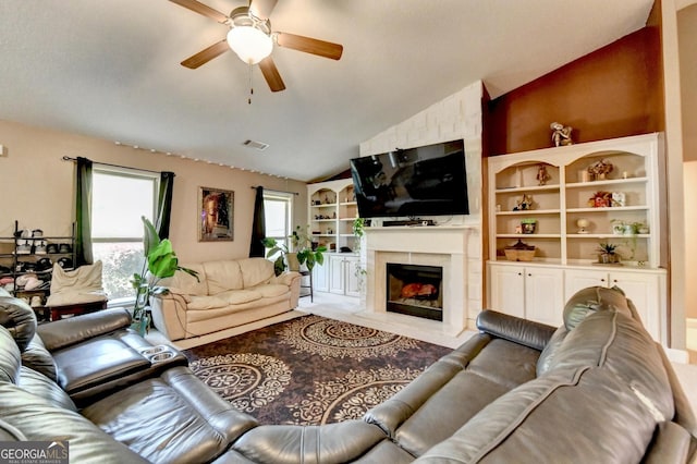 living room with ceiling fan, vaulted ceiling, and a premium fireplace