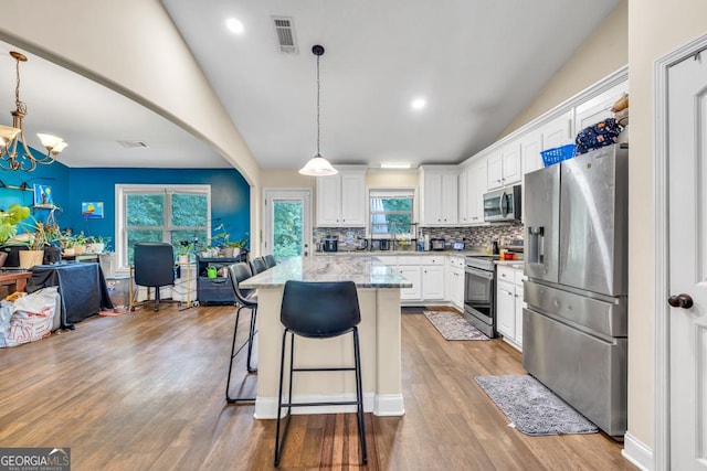 1553 Shoal Creek Dr, Winder, GA 30680 - kitchen featuring appliances with stainless steel finishes, white cabinets, a chandelier, backsplash, and light stone countertops