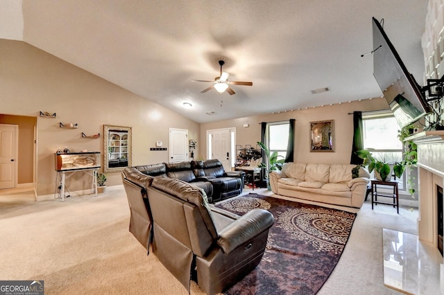 living area with light colored carpet, a ceiling fan, lofted ceiling, a high end fireplace, and baseboards