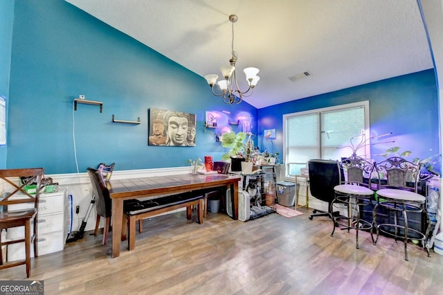 office featuring vaulted ceiling, wood finished floors, a chandelier, and a wainscoted wall