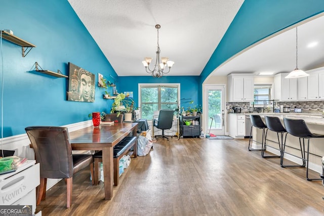 1553 Shoal Creek Dr, Winder, GA 30680 - dining space with a chandelier, wood finished floors, healthy amount of natural light, and lofted ceiling