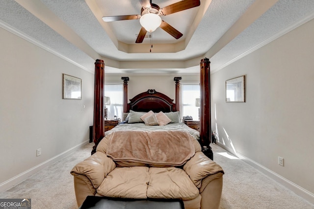 bedroom featuring carpet, a tray ceiling, decorative columns, baseboards, and ornamental molding