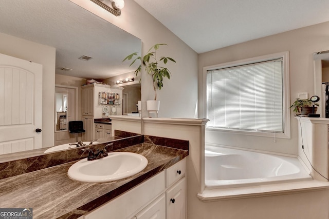 full bath featuring vanity and a garden tub