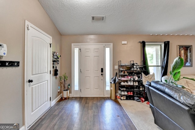 entryway featuring wood finished floors, a textured ceiling, and baseboards