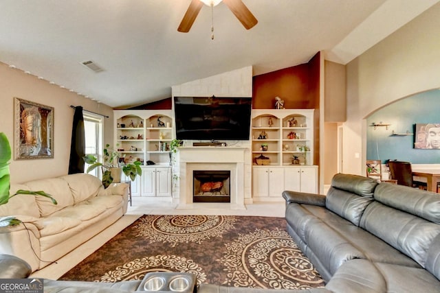 living area featuring lofted ceiling, a ceiling fan, and a premium fireplace