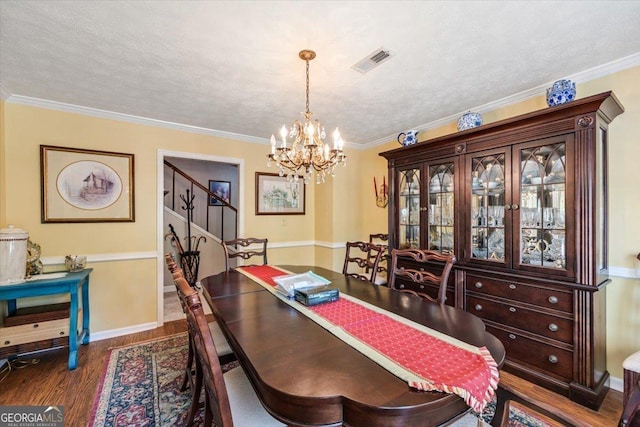 540 Commanche Dr, Macon, GA 31210 - dining space with a notable chandelier, dark wood finished floors, visible vents, baseboards, and ornamental molding