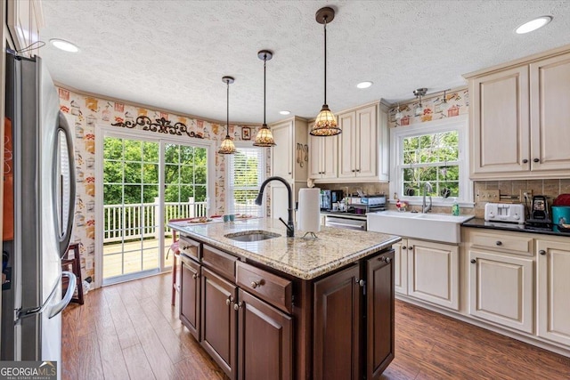 540 Commanche Dr, Macon, GA 31210 - kitchen with freestanding refrigerator, a textured ceiling, cream cabinets, and a sink