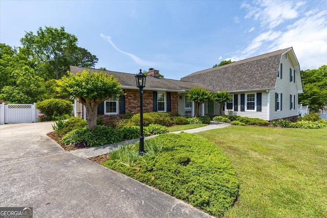 540 Commanche Dr, Macon, GA 31210 - view of front of property with a chimney, brick siding, fence, a shingled roof, and a front lawn