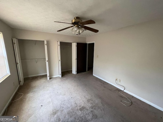 2572 Stratford Ln, Morrow, GA 30260 - unfurnished bedroom featuring two closets, carpet, baseboards, and ceiling fan