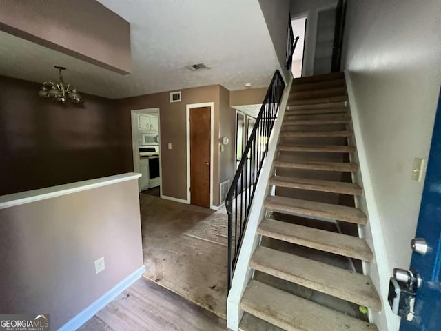 2572 Stratford Ln, Morrow, GA 30260 - staircase featuring baseboards, a chandelier, and visible vents