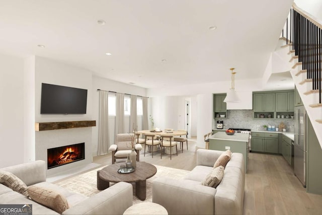 11536 Serenbe Ln, Chattahoochee Hills, GA 30268 - living room featuring stairs, a fireplace with flush hearth, recessed lighting, and light wood-style floors