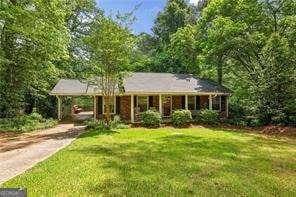 ranch-style house with a front yard, driveway, and an attached carport