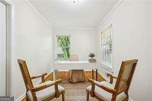 sitting room with ornamental molding, healthy amount of natural light, and baseboards