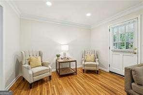 sitting room with ornamental molding, wood finished floors, and recessed lighting