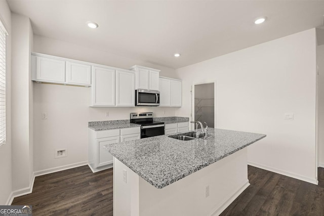 kitchen with a sink, dark wood-style flooring, stainless steel appliances, and white cabinetry