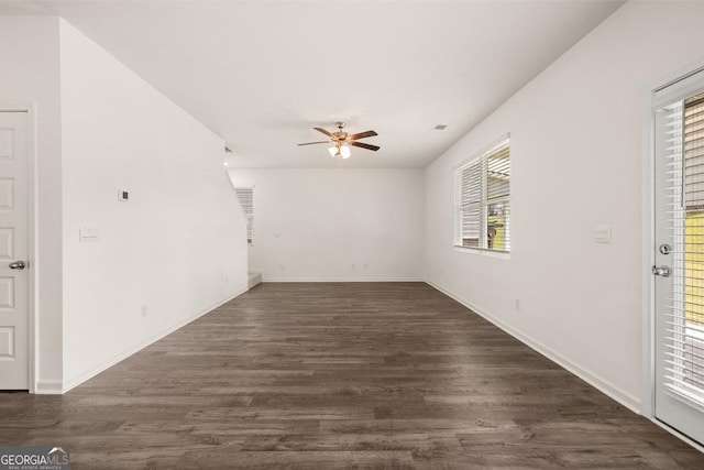 unfurnished room with ceiling fan, baseboards, a healthy amount of sunlight, and dark wood-style floors