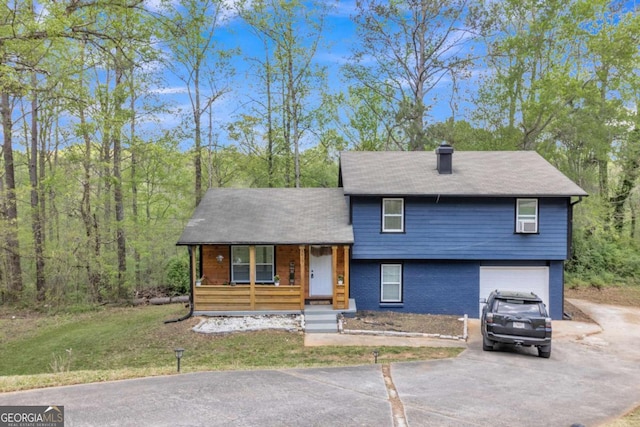 3819 Shane Ct, Ellenwood, GA 30294 - split level home featuring an attached garage, a chimney, a porch, brick siding, and driveway