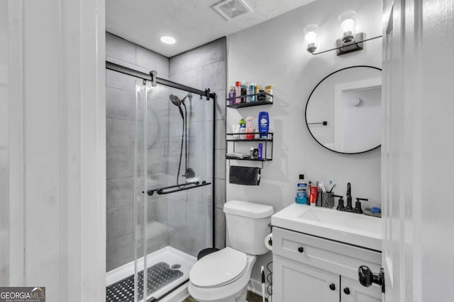 3819 Shane Ct, Ellenwood, GA 30294 - full bathroom featuring a textured ceiling, toilet, visible vents, a shower stall, and vanity