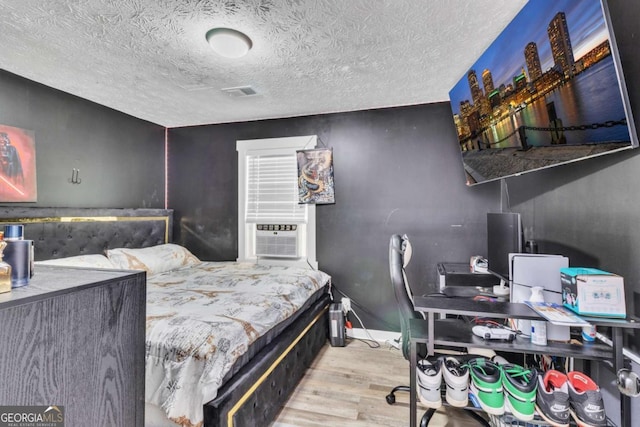 3819 Shane Ct, Ellenwood, GA 30294 - bedroom featuring a textured ceiling, cooling unit, visible vents, and wood finished floors
