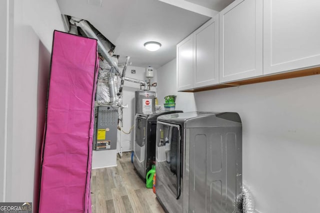 3819 Shane Ct, Ellenwood, GA 30294 - laundry room with washing machine and clothes dryer, water heater, cabinet space, and light wood-type flooring