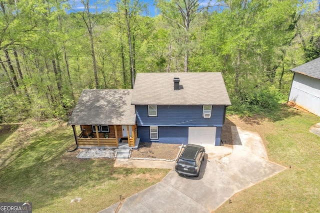 3819 Shane Ct, Ellenwood, GA 30294 - view of front of house with a forest view, covered porch, an attached garage, concrete driveway, and a front lawn