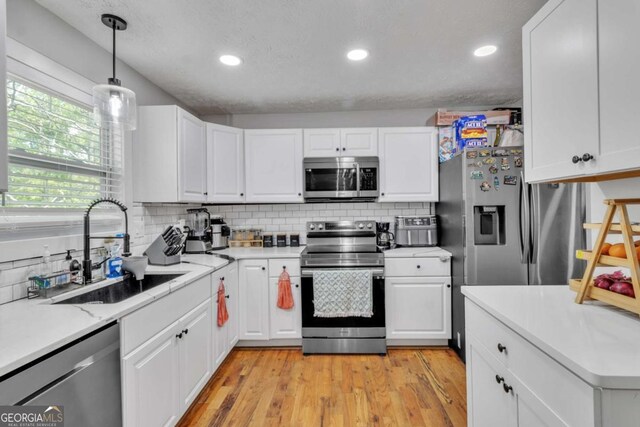 3819 Shane Ct, Ellenwood, GA 30294 - kitchen featuring a sink, white cabinets, backsplash, light countertops, and appliances with stainless steel finishes