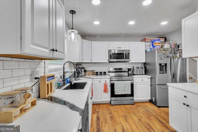 3819 Shane Ct, Ellenwood, GA 30294 - kitchen featuring stainless steel appliances, white cabinetry, light countertops, and light wood-style floors